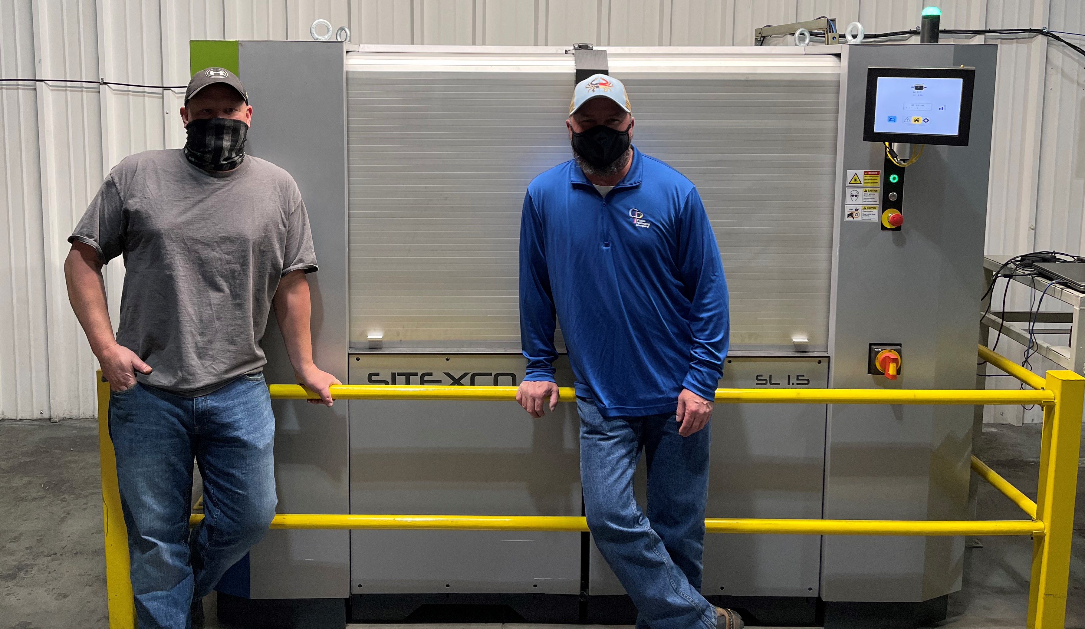 two men standing in front of a laser anilox cleaning system